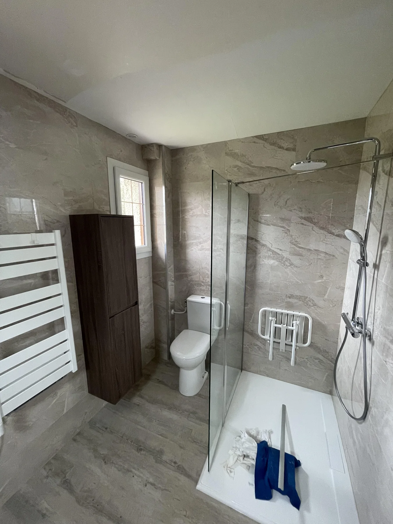 Douche, WC et rangements dans une salle de bains beige