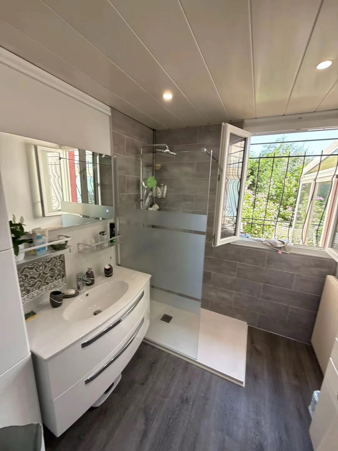 Meuble vasque et douche dans une salle de bains grise